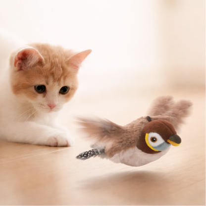 Cat playing with a bird-shaped toy on a light surface